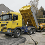 Transporte Grixa - 3-Achs-Seitenkipper in Kippposition mit Bagger